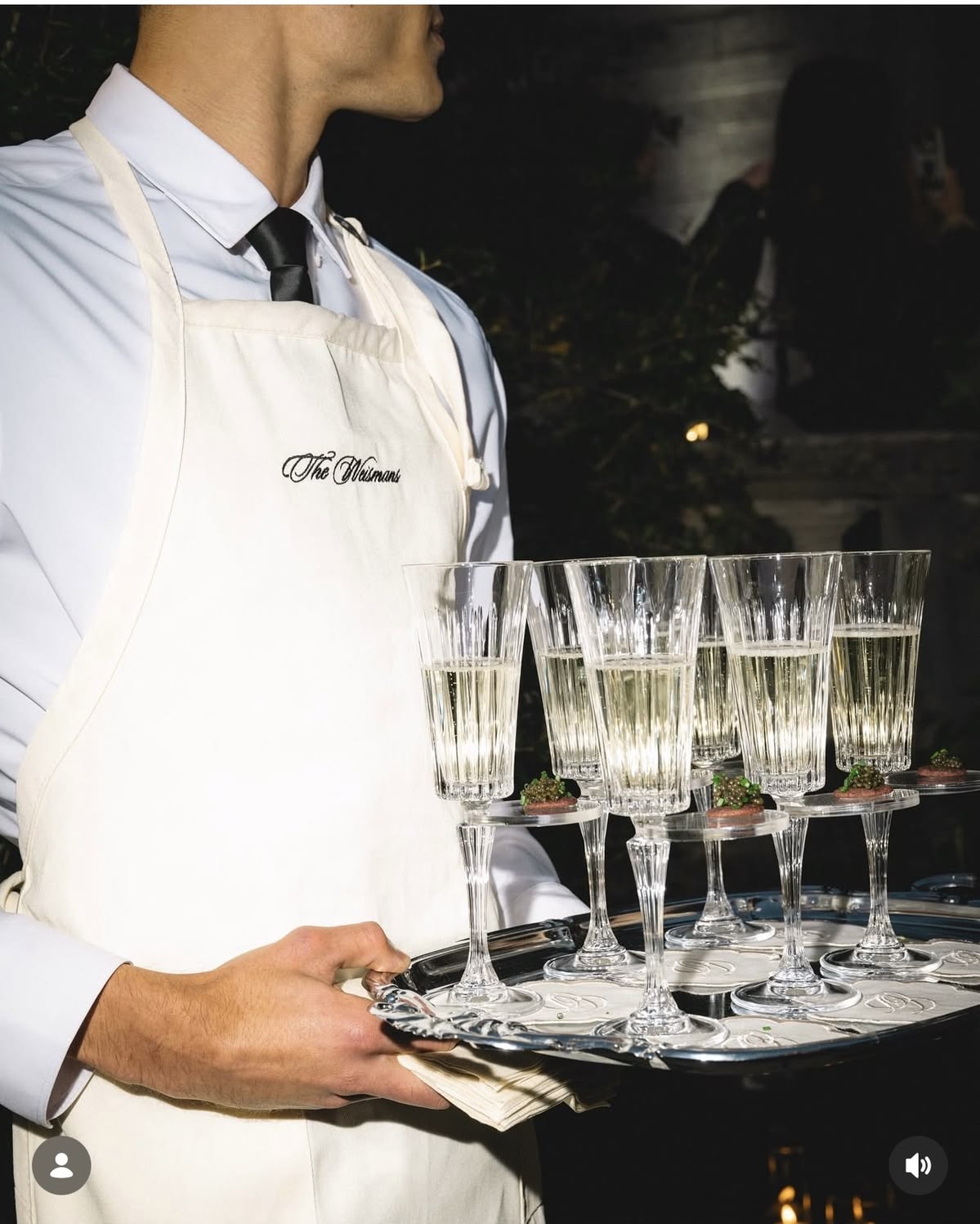 Waiter carrying a silver tray of champagne glasses
